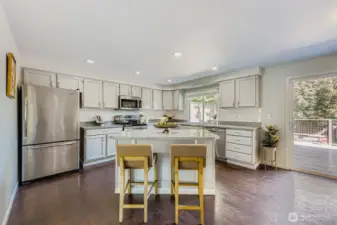 Kitchen enjoys plenty of cabinet space and an island with eating space.