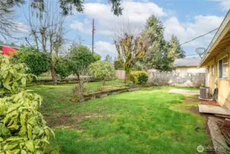 Deep and wide backyard with some shade from established trees.