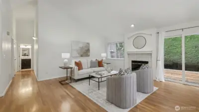 Living room with high vaulted ceilings. Looking down the hallway to BRs