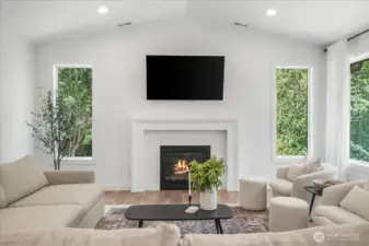 Open living room w/ vaulted ceilings & large windows for natural lighting