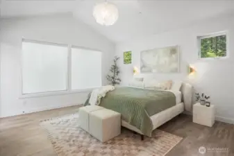Vaulted ceiling primary bedroom on the main equipped w/ motorized blinds & a door to the your upper deck
