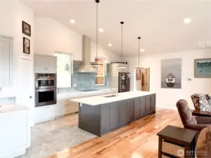 Open door at the far end of the island is the hallway to the utility room and attached 2 car garage.