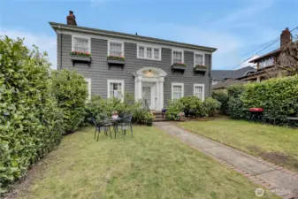 Lovely 1919 Colonial charmer.  Fully fenced.  Huge back garden/yard leading to 2-car garage on alley.
