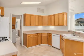 Another view of the kitchen. To the left is the utility room (with access to the garage), and through the utility room is an access point to the primary suite bath.