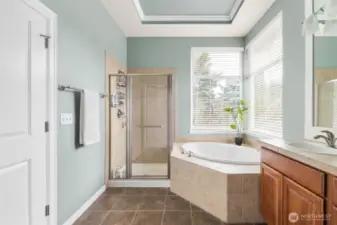 The spacious primary bathroom features a tiled corner tub, double sinks, and plenty of counter space for added convenience.