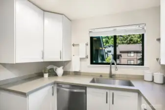 Beautiful quartz countertops in the recently renovated kitchen with large window.