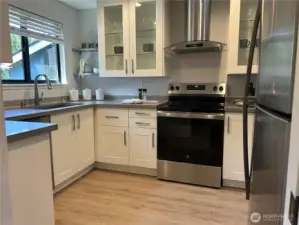 New stylish and low-maintenance vinyl plank flooring enhances the kitchen and entry hall.