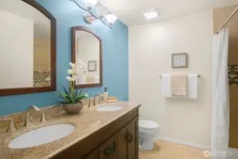 The primary bathroom boasts dual vanities and a spacious walk-in shower for added comfort and convenience.