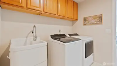 This super-spacious laundry room features an awesome utility sink with a handy storage drawer underneath, making everyday tasks easier and more organized.