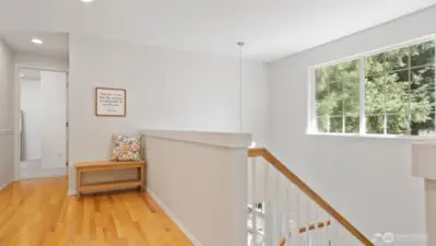 At the top of the stairs, a spacious landing with like-new hardwood floors greets you, while the front window frames that beautiful forest view once more and fills the space with abundant natural light.