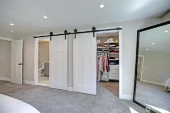 Barn door entry to primary bath and walk-in closet.