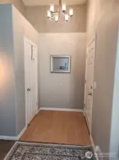 Entry into the home, wel lit and inviting. To the left is a coat closet door and the livingroom.