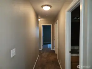 Back from the livingroom is a hallway leading to the guest bath, laundry and bedrooms.