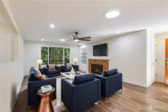 Wooded view through the living room windows and a gas fireplace.