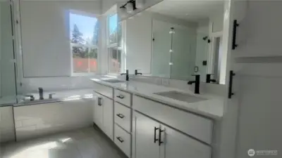 Hotel-Style primary bath includes 12x24 tile floors, quartz counters, black hardware, plumbing and lighting.  Soft close cabinets and drawers.  Huge soaking tub and frameless tiled walk-in shower.  A dream walki-n closet and separate water closet for privacy.