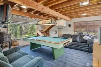 Pool interior! Wood burning free standing stove, obviously a pool table, microwave, seating area.