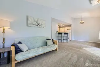 View from Living Room to Dining Room with Chandelier + Vaulted Ceilings