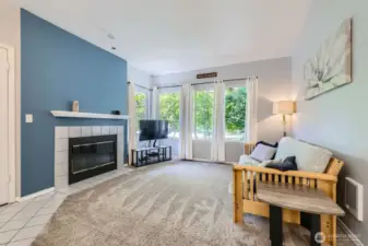 Living Room has Wood-Burning Fireplace with Tile Surround & Wood Mantle