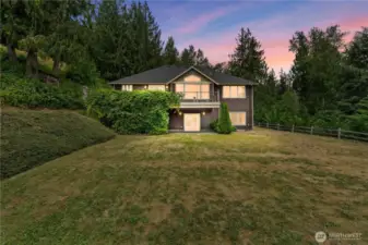 There is a spacious upper-level deck that offers an ideal spot for outdoor lounging and entertaining. Directly below the deck, a patio area provides a perfect transition from indoor living to outdoor. The lower patio is easily accessible from the downstairs level and extends out onto the private backyard. These spaces are perfect for gatherings, outdoor dining, or simply enjoying the mountain view and peaceful landscape