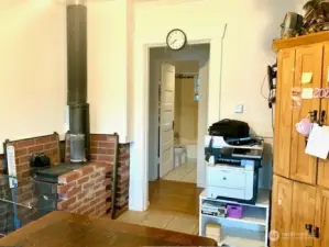 Small wood burning stove in dining room adds warmth as well as heats the home.