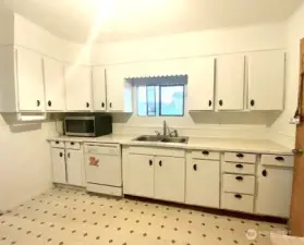 Kitchen has lots of cupboards for storage and countertop workspace!