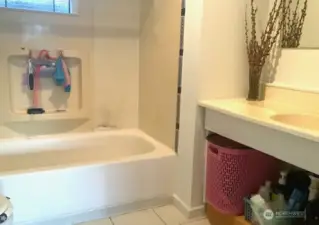 Main bathroom with soaking tub and tiled floor.