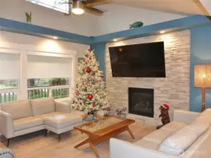 Stylish propane fireplace surrounded by the wall-to-ceiling rock wall.