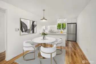The spacious condo has a cozy dining room area adjacent to the kitchen with all new appliances, cabinetry and quartz countertops.  The staging in this photos is virtual.