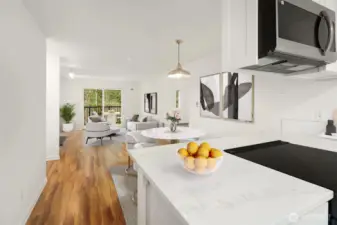 The sunny kitchen overlooks a dining room space with living room with terrace beyond.  Hard surface vinyl tile flooring.  No Carpet!