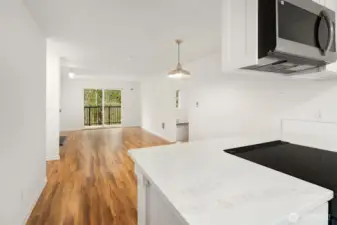 The sunny kitchen leads to a dining room, living room with wood burning fireplace and peaceful terrace overlooking a preserved green belt.