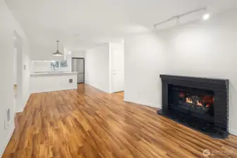The roomy living room features a wood burning fireplace and hard surface LVT flooring.