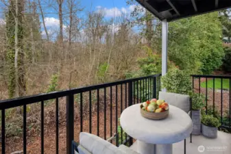 The exterior terrace overlooks a wooded open space and includes a large storage closet.