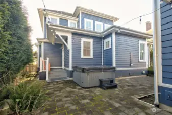 The back of the home is private and has custom pavers and hot tub with outdoor shower.