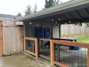 Covered carport with a gate, currently used as a spacious outdoor area, offering versatility for various uses and providing both convenience and flexibility