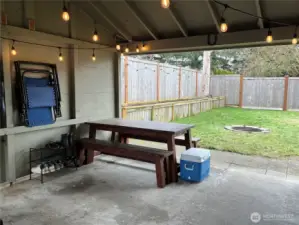 Covered carport, currently used as an outdoor living space, offering a versatile area that can be enjoyed year-round.