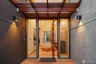 This private entryway into the home through a statement pivot door and grand foyer unfolds into the glass-enclosed atrium, a Zen-like sanctuary framed by floor-to-ceiling windows.