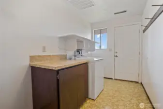The utility room is located in the lower level and has a door to access the outside.