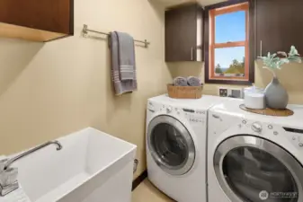 Lower floor laundry room with front loading W/D and deep sink