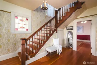 Warm, welcoming entry with beautiful wood bannister, staircase and wood flooring set the tone for this turn-of-the-century home.