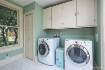Laundry room with great storage, marble tiled flooring, and sliding glass to embrace all the light and provide access the South-facing deck and private backyard.