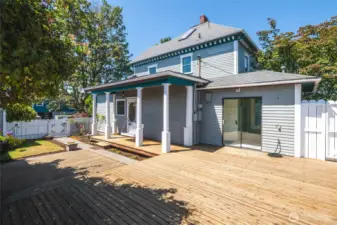 Another view of the private, fenced back yard with enormous deck for outdoor entertainment. Sliding glass door leads to laundry area. There is alley access and a small garden shed for all your tools, plus a hobby room/shop, additional storage room and one car garage.