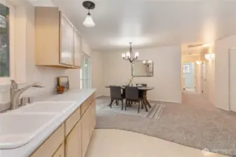 Dining space just off kitchen, hall leads to 2 more bedrooms, laundry room & garage access