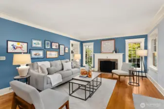 The living room features hardwood floors, an elegant framed 1920's era Batchelder tiled fireplace, and sunlit windows—historic artistry meets modern comfort.  Crown molding abounds to round out a very quintessential craftsman feel.