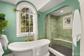 Recently remodelled, this spa-inspired retreat features a new soaking tub beneath this arched window makes a fantastic statement.  The handmade tile for the walk in shower, featuring a thermostatic shower head, brings the feel of nature into the space.