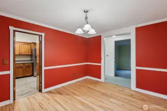 The dining room has access to the kitchen, and the living room can be seen through the hallway.