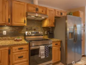 Stainless steel appliances highlight the warm tones of the kitchen.