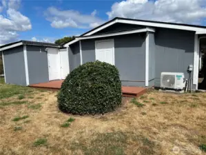 View of the back of the house with storage areas and deck.