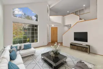 BRIGHT AND INVITING LIVING ROOM HAS PLENTY OF SPACE FOR FURNITURE, AND ABUNDANT NATURAL LIGHT.