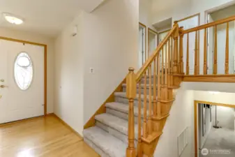 The light and bright formal foyer entry has hardwood floors.