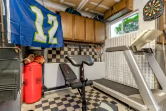There is an approximate 5x5 shop space adjacent to the garage with a window and upper cabinets that has been converted to use as a small gym.  The ceiling is sheetrocked and could use some new paint for the garage ceiling.